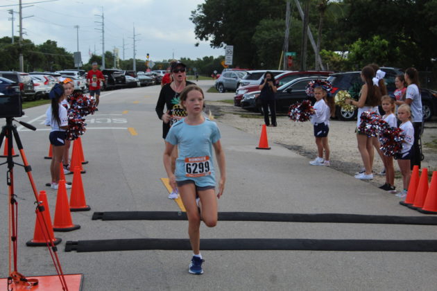 a group of young girls running down a street