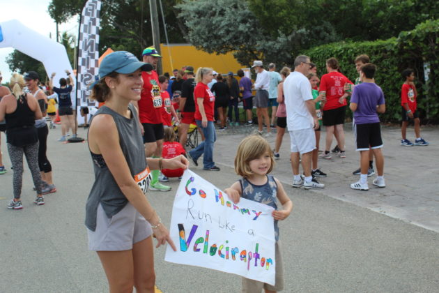 a woman and a little girl holding a sign