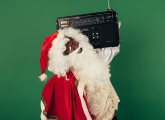 a man dressed as santa claus holding a boombox