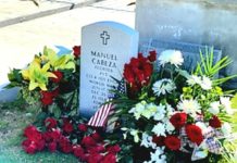 a grave with flowers and an american flag