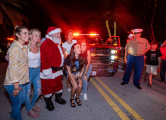 a group of people dressed as santa clause standing in front of a truck