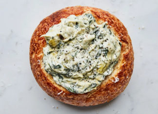 a bread bowl filled with spinach and cheese