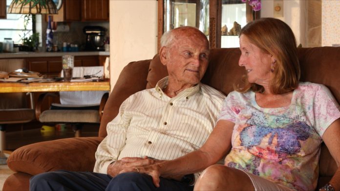 a man and a woman sitting on a couch in a living room