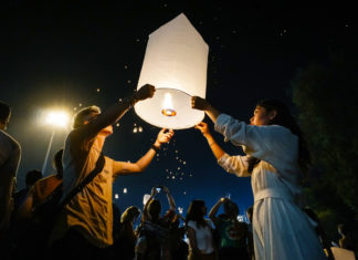 a couple of people that are holding a paper lantern