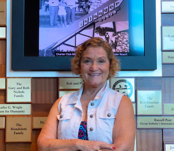 Bonnie-Barnes-2 a woman standing in front of a wall of plaques