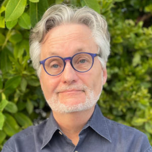 a man wearing glasses and a blue shirt