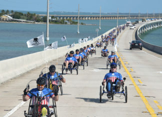 a group of people in wheelchairs riding down a road