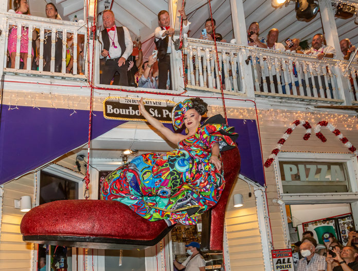 a woman in a colorful dress sitting on a red chair