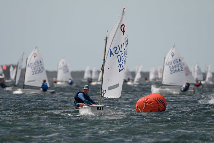 multiple-sailboats a group of people on small boats in the water