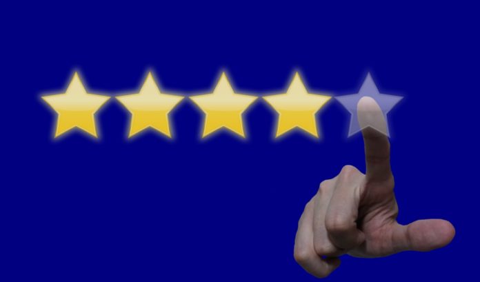 review-5205754 a hand pointing at five stars on a blue background