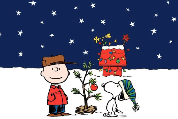 a charlie brown christmas card with a tree and a man