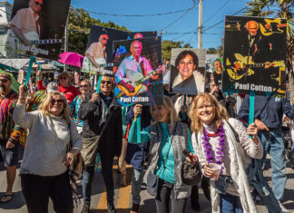 a group of people walking down a street holding signs