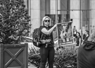 FROM THE FAMOUS FOX: HOW TO HELP STOP USE OF FUR a woman holding a sign in front of a building