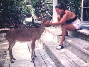 a woman petting a deer on a porch