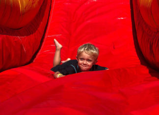 a young boy sliding down a red slide