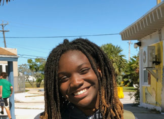 a woman with dreadlocks standing in front of a building