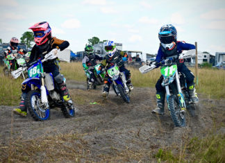 a group of people riding dirt bikes on top of a dirt field