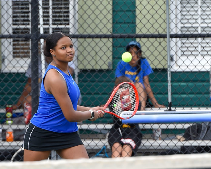 a woman holding a tennis racquet on a tennis court