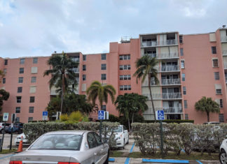 a parking lot with cars parked in front of a pink building