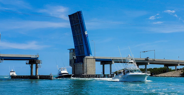 a boat traveling under a bridge in the ocean