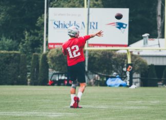 LIFE LESSONS FROM FOOTBALL PRESS CONFERENCES a man throwing a football on top of a field