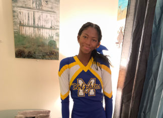 a woman in a cheer uniform standing in a living room