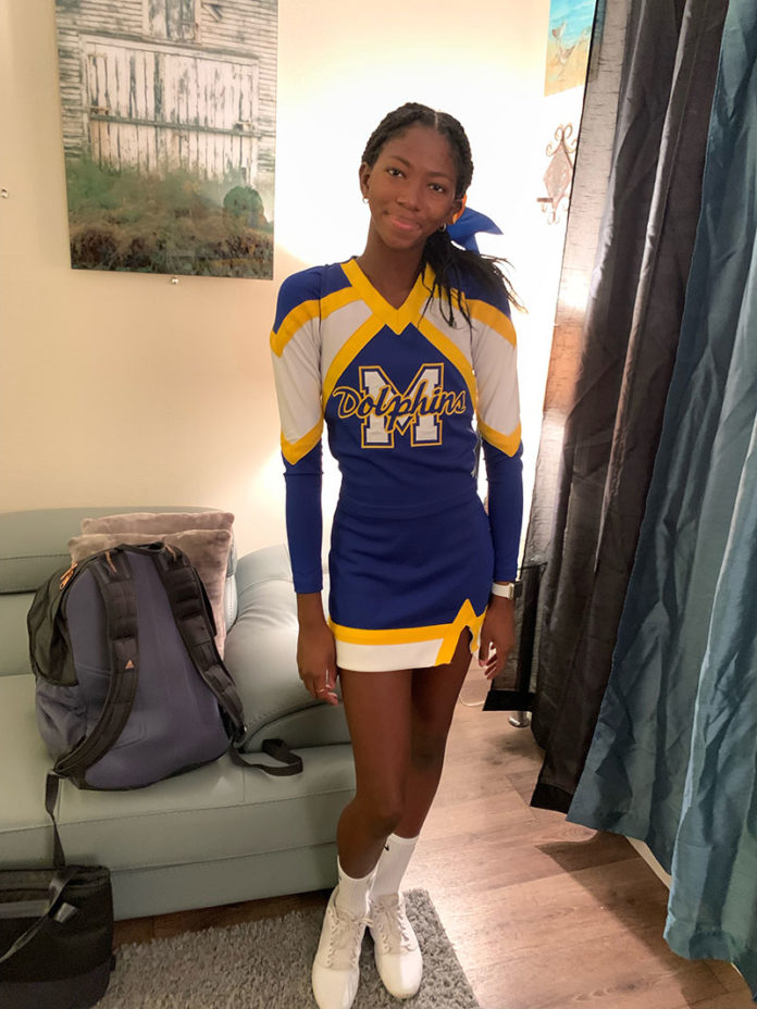 a woman in a cheer uniform standing in a living room