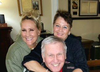 TOMMY JOHN, BASEBALL PITCHING GREAT & NAMESAKE OF LANDMARK ELBOW SURGERY, JOINS THE PODCAST a man and two women hugging each other in a living room