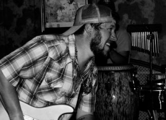 a black and white photo of a man playing a guitar