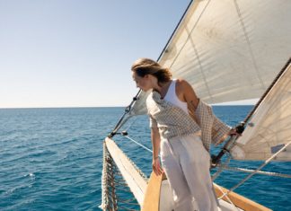 a woman standing on the deck of a sailboat