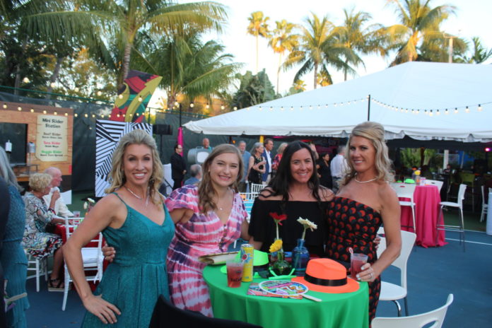 a group of women standing around a table