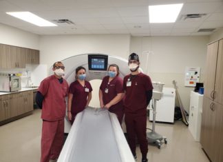 a group of doctors standing around a hospital bed