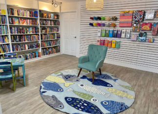 a room with a book shelf and a blue chair