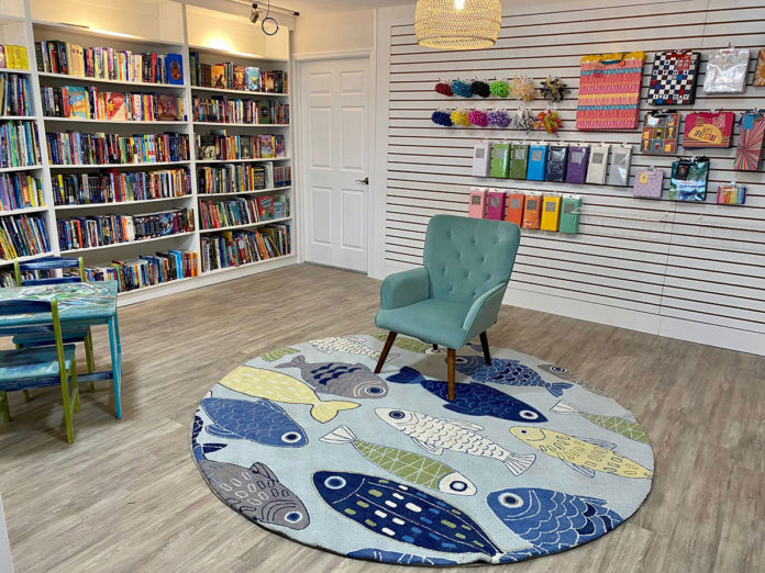 a room with a book shelf and a blue chair