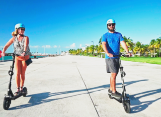 a man and a woman riding scooters on a sidewalk