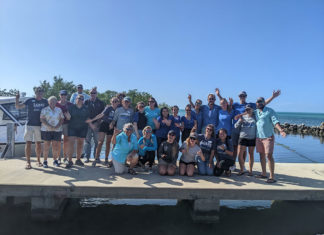 a group of people posing for a picture on a pier