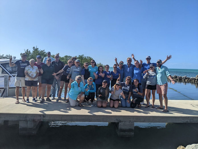 a group of people posing for a picture on a pier