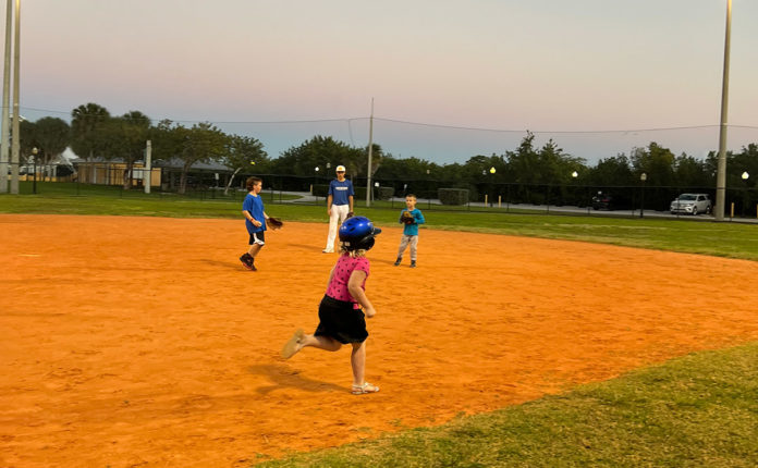 IMG_1477 a group of young children playing a game of baseball
