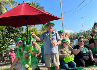 a group of people sitting under a red umbrella