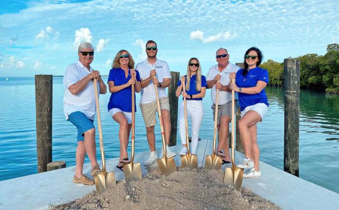 a group of people standing on a dock holding shovels