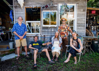a group of people sitting outside of a house