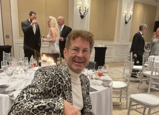 a man in a leopard print jacket sitting at a table