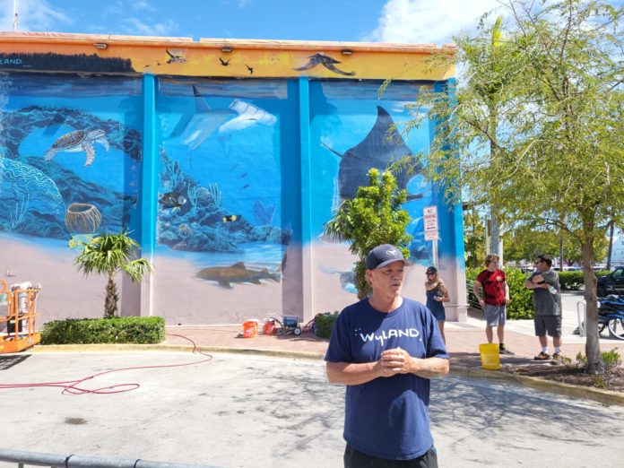 a man standing in front of a mural