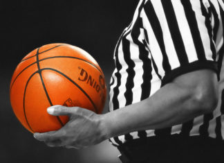 a referee holding a basketball in his hand