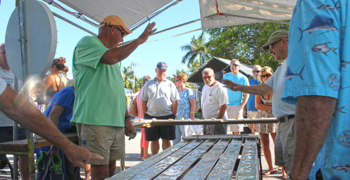 a group of people standing around a wooden table