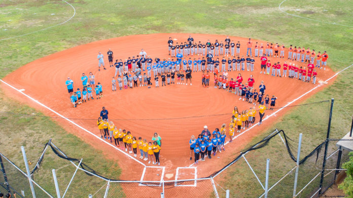 a group of people standing on top of a baseball field