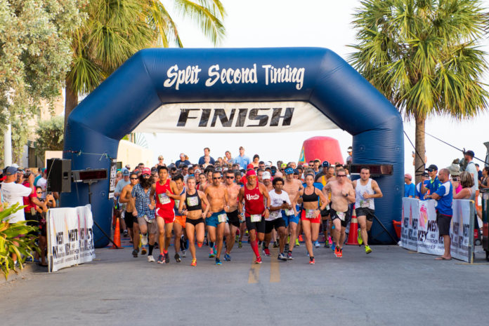 a group of men running under a finish line