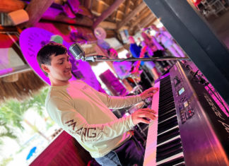 a young man is playing the piano in a bar