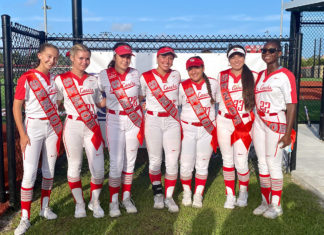 a group of women in red and white baseball uniforms