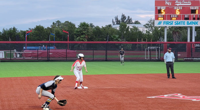 Lady-Conchs a group of baseball players standing on top of a field